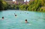 switzerlands summer hack people swim through a river to get home from work