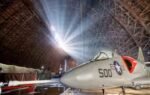 a military jet displayed inside the massive world war ii era aircraft hangar in oregon us